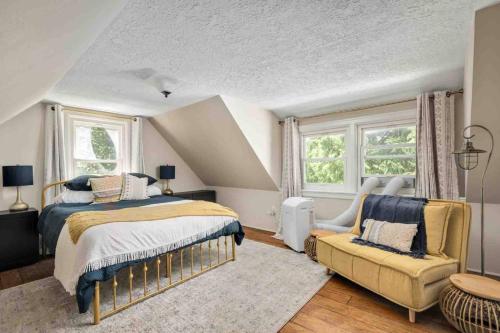 a bedroom with a bed and a chair and windows at Riverwood Retreat in West Linn