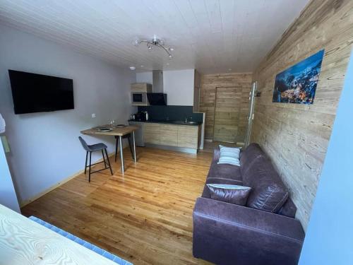 a living room with a brown couch and a table at Logement avec jacuzzi Murat in Murat