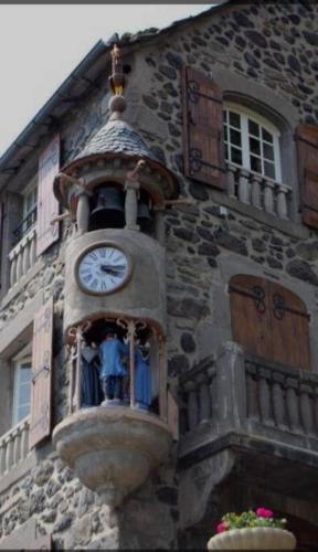 a clock on the side of a building at Logement avec jacuzzi Murat in Murat