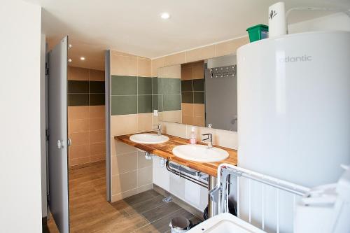 une salle de bain avec deux lavabos et un miroir dans l'établissement Équi'séjour, à Pordic