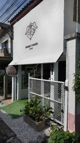 a building with a fence and a sign on it at Friend's House Arak in Chiang Mai
