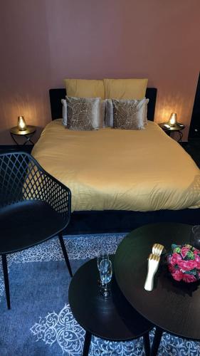 1 dormitorio con 1 cama con 2 sillas y mesas en Love room, en Melun