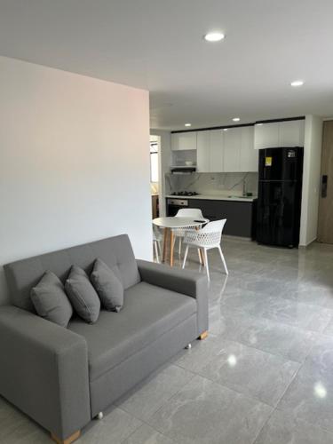 a living room with a couch and a kitchen at Apartamento moderno y cómodo cerca a Viva Envigado in Envigado