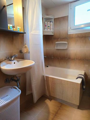 a bathroom with a sink and a bath tub and a sink at Marlene in Karavomylos