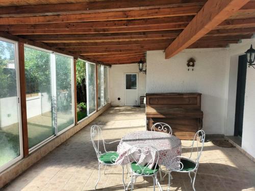 un patio avec une table, des chaises et des fenêtres dans l'établissement Maison Familiale à la campagne, à Saint-ouen-dʼAunis