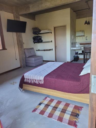 a bedroom with a large bed and a couch at Suite Ana - Casa Tapera Nova in Conceição da Ibitipoca