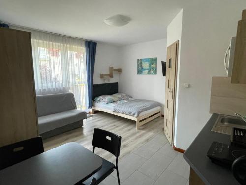 a small living room with a bed and a couch at Best in Karwia