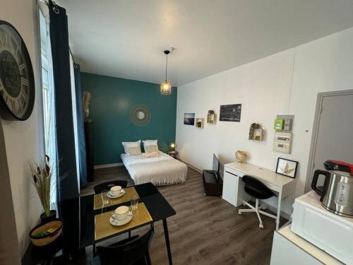 une chambre d'hôtel avec un lit, un bureau et une table dans l'établissement Le Refuge des Marées - Idéalement situé, à Boulogne-sur-Mer