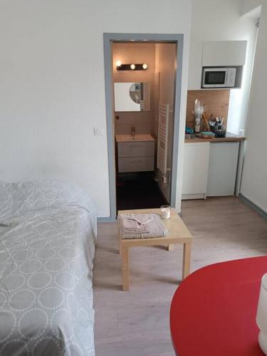 Cette chambre comprend un lit, une table et une cuisine. dans l'établissement Studio avec balcon, à Pau