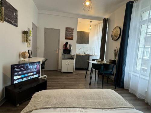 une chambre avec un lit et une cuisine avec une table dans l'établissement Le Refuge des Marées - Idéalement situé, à Boulogne-sur-Mer