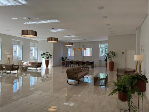 a lobby with couches and chairs in a building at Hotel Roma in São Sebastião