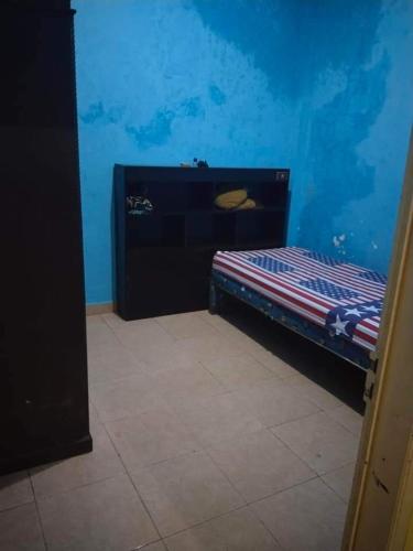 a bedroom with a bed in a blue room at Hong Kost Homestay Putra Csb Mall in Cirebon