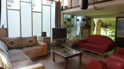 un salon avec deux canapés et une télévision dans l'établissement Splendide Loft Central - JO 2024 - Stade de France, à Saint-Denis