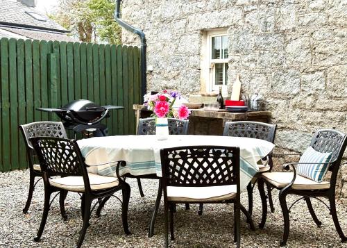 a table and chairs with a table and a fence at The Gables Cottage in Rathvilly