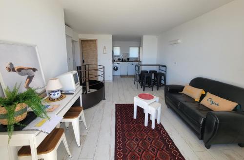 un salon avec un canapé noir et une table dans l'établissement Le Cabanon, pieds dans l'eau, vue exceptionnelle, à Fréjus