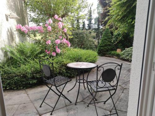 a patio with a table and two chairs and flowers at Ferienwohnung Stadtnähe in Calw in Calw