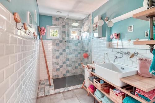 une salle de bain avec un lavabo et une douche dans l'établissement Villa la p'tite guinguette, à Salles