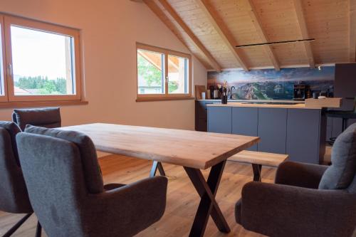 a dining room with a wooden table and chairs at Chalet Hildegard in Pfronten