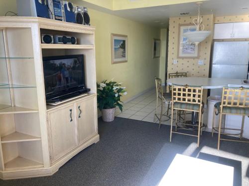 a living room with a television and a dining room at Ocean Walk Resort - Amazing Ocean Front View in Daytona Beach