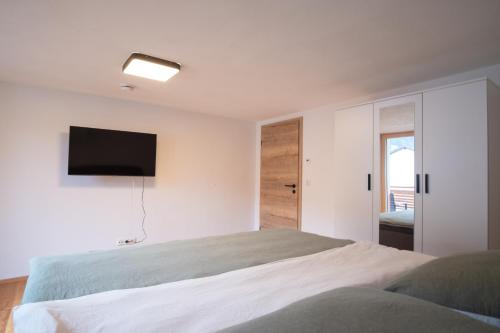 a bedroom with a bed and a television on the wall at Chalet Hildegard in Pfronten