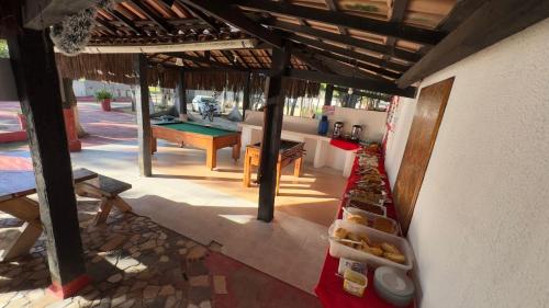an outdoor kitchen with a table and a pool table at Pousada Mutary in Santa Cruz Cabrália