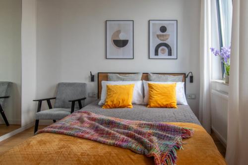 a bedroom with a bed with orange pillows at Studio Olesińska in Warsaw
