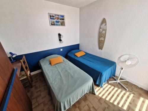 Cette chambre comprend 2 lits jumeaux et un bureau. dans l'établissement Résidence LE GINESTOU - Maisons & Villas pour 4 Personnes 24, à Port-Leucate