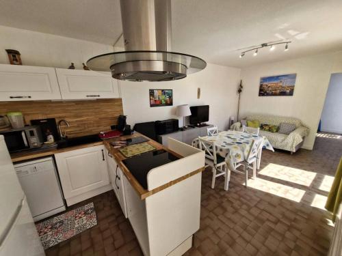 une cuisine et un salon avec une table et une salle à manger dans l'établissement Résidence LE GINESTOU - Maisons & Villas pour 4 Personnes 24, à Port-Leucate