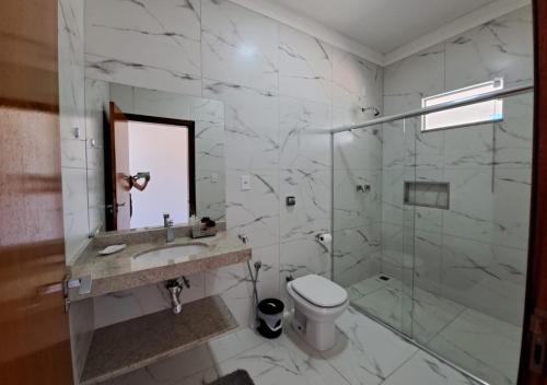 een badkamer met een douche, een toilet en een wastafel bij Mirante Mar de Minas - Casa para Temporada Lago de Furnas pertinho dos Canyons in São José da Barra