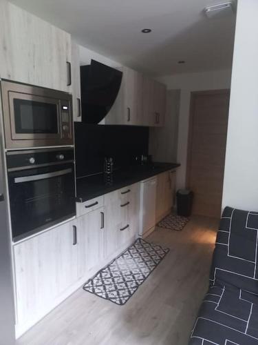 une cuisine avec un micro-ondes et une cuisinière four supérieur dans l'établissement Chez Ange, à Saint-Étienne-de-Cuines