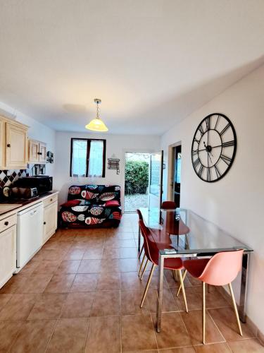 une cuisine et une salle à manger avec une horloge murale dans l'établissement Cottage 43 m2 2 épis - Plage à 400m - PARKING Jardin TERRASSE Wifi, à Six-Fours-les-Plages