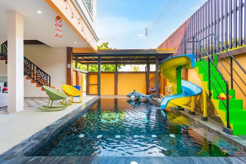 a pool in the middle of a house with a water slide at 99 Pool Villa in Jomtien Beach