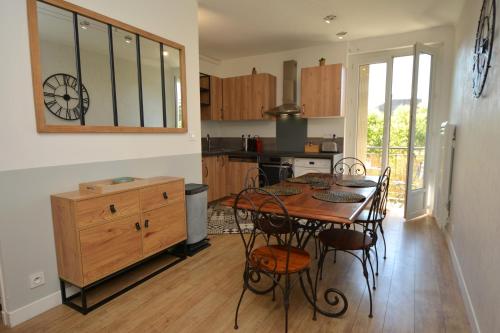 une cuisine avec une table et des chaises dans une pièce dans l'établissement BellaVita - Cosy & Moderne - Proche des remparts - Climatisation, à Avignon