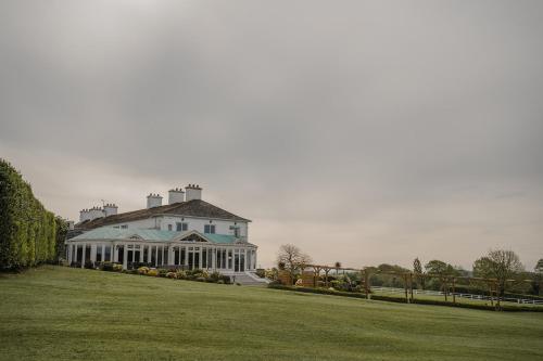 a large white house with a lawn in front of it at Crover House Hotel & Golf Club in Mountnugent
