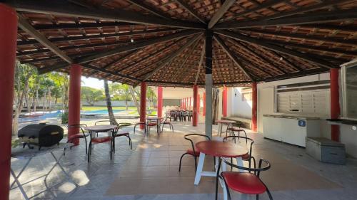 a patio with tables and chairs under a large roof at Pousada Mutary in Santa Cruz Cabrália