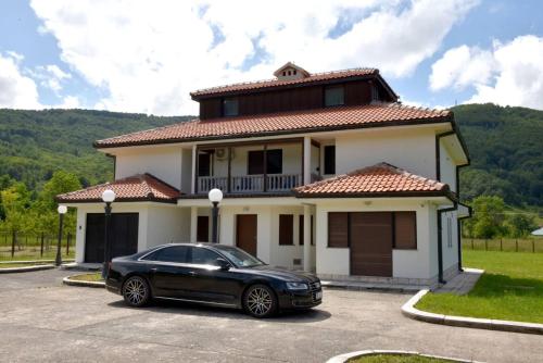 a black car parked in front of a house at Villa Tara in Feratovo Polje