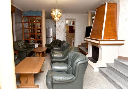 a living room with leather furniture and a fireplace at Villa Tara in Feratovo Polje