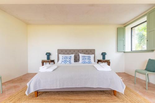 ein Schlafzimmer mit einem großen Bett und zwei Stühlen in der Unterkunft Casa da Raposeira Douro Valley in Armamar