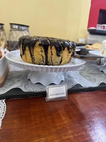 a chocolate cake on a plate on a table at Hotel Roma in São Sebastião
