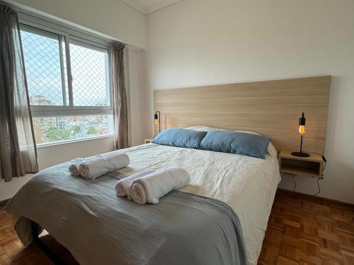 a bedroom with a large bed with towels on it at Tigre Center Tower i - Con piscina y seguridad 24hs - Opcional cochera in Tigre