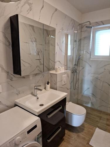 a bathroom with a sink and a toilet and a shower at Villa Toni II in Biograd na Moru