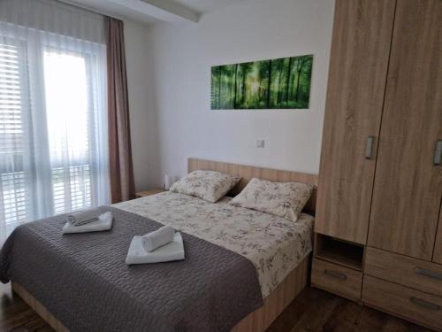 a bedroom with a bed with two towels on it at Villa Toni II in Biograd na Moru