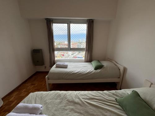 two beds in a small room with a window at Tigre Center Tower i - Con piscina y seguridad 24hs - Opcional cochera in Tigre