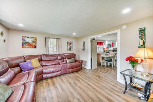 a living room with a leather couch and a table at Modern Cape Charles Home 1 Mi to Kiptopeke Beach! in Cape Charles