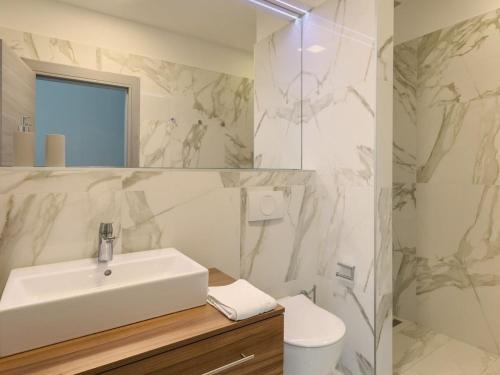 a white bathroom with a sink and a toilet at Villa Adria Blue in Kraljevica