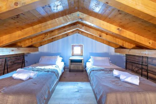 two beds in a room with a wooden ceiling at Villa Kiara in Unešić