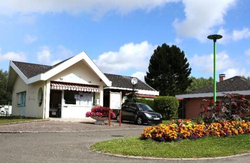 une voiture garée devant une maison fleurie dans l'établissement Parcelle 39, à Incheville