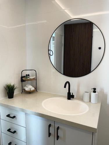 a bathroom with a sink and a mirror at BaGiva צימרים in Giv'at Avni