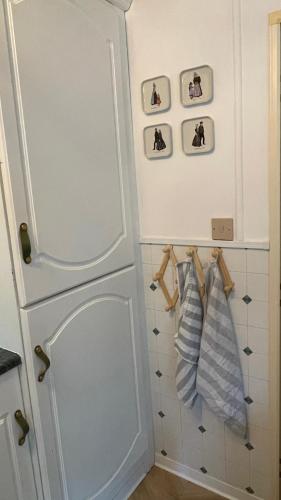 a kitchen with a white refrigerator and some towels at SAYANG26 gezellige gezinsvriendelijke stacaravan op familiecamping De Vossenburcht in natuurgebied Reestdal - no workers allowed in IJhorst