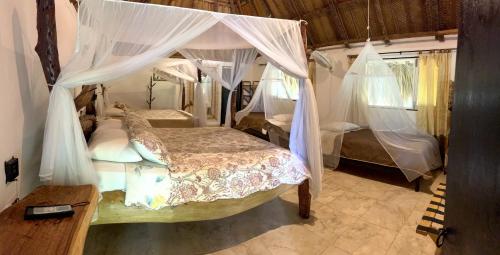 a bedroom with a canopy bed with mosquito nets at Quetzal Dorado Eco-Lodge by Mareygua in El Zaino